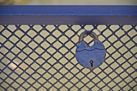 Blue iron lock on blue bridge railingの写真素材