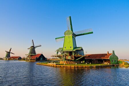 Old Dutch windmills at Zaan river in setting sun at Zaanse Schans, Netherlands at spring.の写真素材