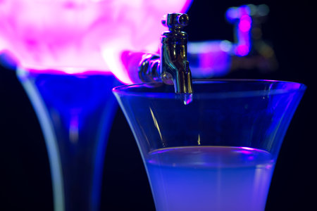 Classic ritual of glass of absinth and dripping water fountain. With blue light.の写真素材