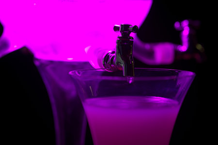 Classic ritual of glass of absinth and dripping water fountain. With violet light.の写真素材