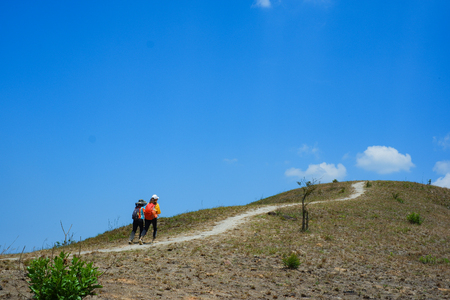 Climbers on the grassy hill. Group of young people walking on a green lawnの写真素材