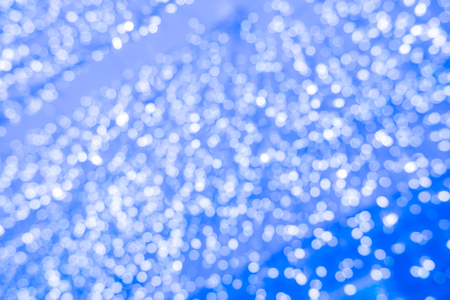 Abstract blue bokeh circles for Christmas background. Royalty high-quality free stock photo of Christmas light overlay background. Holiday glowing backdrop. Defocused background with blinking starsの写真素材