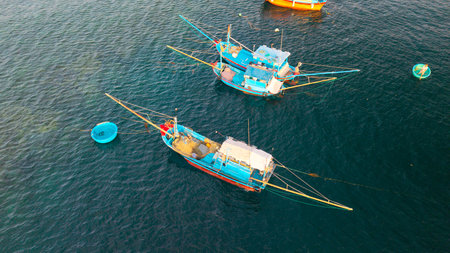 Fishing harbor with wooden boats and coastal houses, authentic village life in Vietnam, seascape with mountains, culture, travel and tourism scene, marine lifestyle and cultureの写真素材