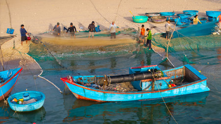 Aerial view of fishermen hauling nets on beach, authentic culture, rural lifestyle, seafood harvest...