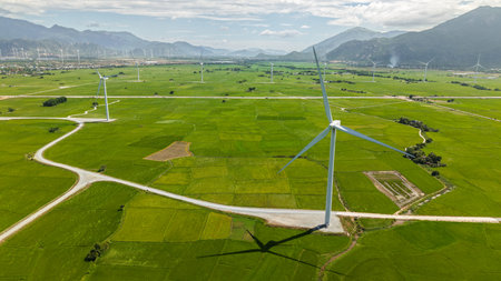 Green rice fields with wind turbines in rural Vietnam. High-quality stock of renewable energy and...