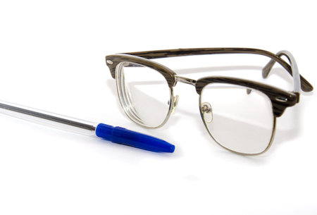 Glasses and pen on the white isolated background