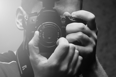 Black and white photo of the photograph and his camera in handの写真素材