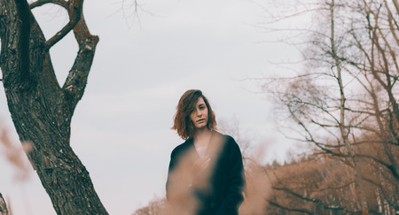 Young pretty girl on the beach of lake in spring timeの写真素材