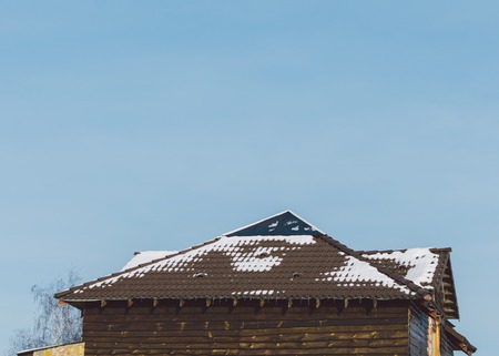 Wood house in village with roof in snow in winter timeの写真素材