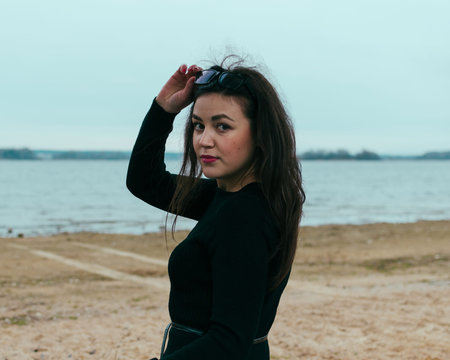 Young pretty girl on the ebach of sea in autumn timeの写真素材