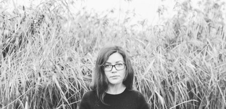 Black and white portrait of the young pretty woman in glasses