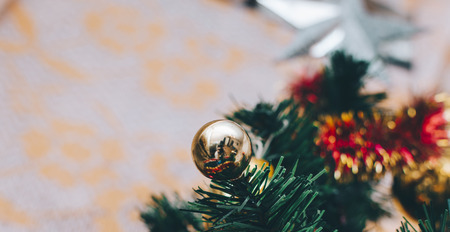 Closeup of bauble hanging from a decorated Christmas tree.の写真素材