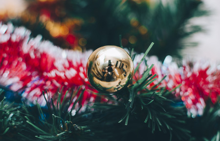 Closeup of bauble hanging from a decorated Christmas tree.の写真素材