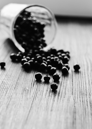 Spill fresh blueberries on table from glass. Wooden background suitable for text. Black and white photoの写真素材