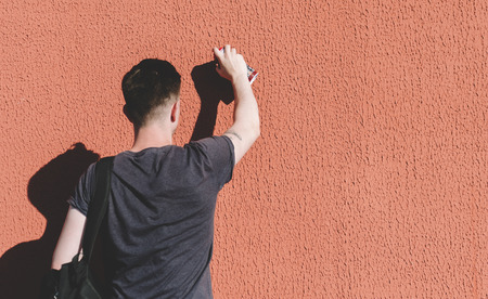 Man writing graffiti on the urban wallsの写真素材