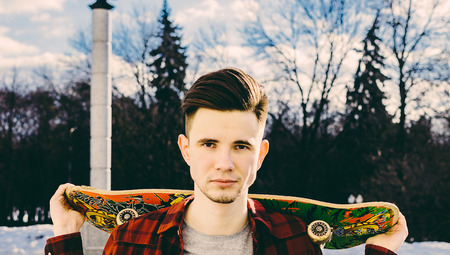 Young man with skateboard in the city parkの写真素材