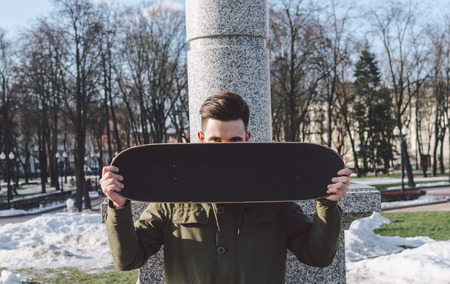 Young man with skateboard in the city street parkの写真素材
