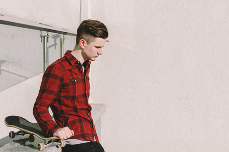 Young man with skateboard on the city streetの写真素材