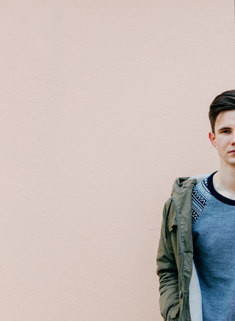 Portrait of the half young man on the pink wall backgroundの写真素材