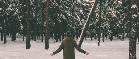 Young man in winter forest after the snowfallの写真素材