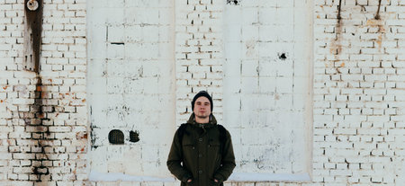 Young man staying near the old brick wallの写真素材
