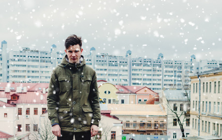 Young man on the rooftop in winter time with snowの写真素材