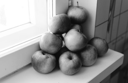 Black and white photo of the group of apples on the home windowの写真素材