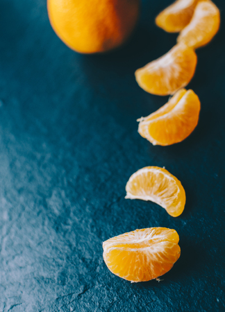 Mandarins on the black background on home tableの写真素材