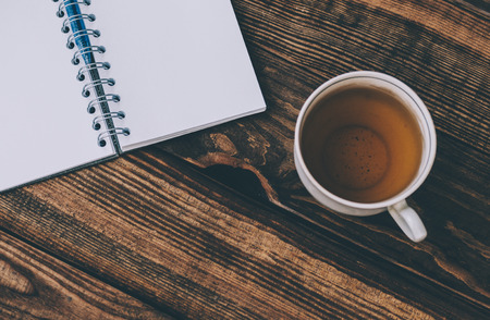 Cup of tea and notepad with pen on wood rustic backgroundの写真素材