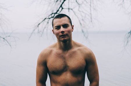 Young and muscle man standing near the water outdoorsの写真素材