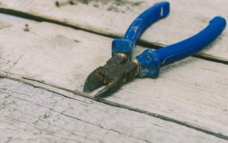 Old blue pliers on the wooden tableの写真素材