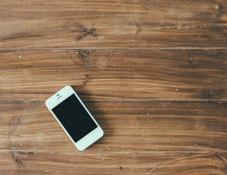White phone on wood vintage office tableの写真素材
