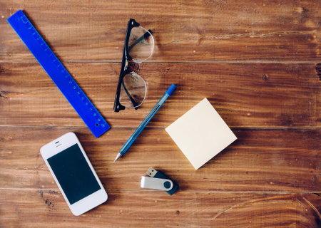 Phone, ruler, pen, glasses and other on wood table