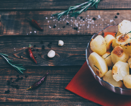 Roasted potato with rosemary in plate on home kitchen tableの写真素材