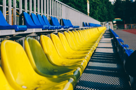 Blue and yellow empty stadium seats in school