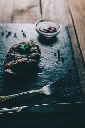 Meat steak and basil on wood rustic tableの写真素材