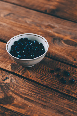 Blueberry in plate on wooden rustic kitchen tableの写真素材