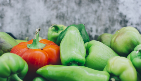 Red and green pepper on the gray wall backgroundの写真素材
