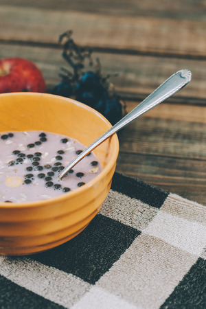 Bowl of muesli and yogurt with fresh grape and applesの写真素材