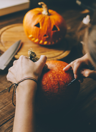 Girl worked on wooden table with pampkin for halloweenの写真素材
