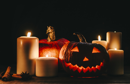 Halloween pampkin on black background with candles and smokeの写真素材