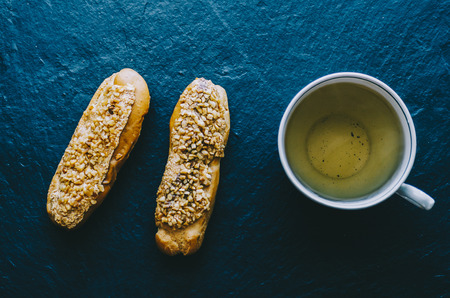 Eclairs on the black stone background with teaの写真素材