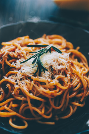 Pasta with tomato, rosemary and chesse on wooden rustic tableの写真素材