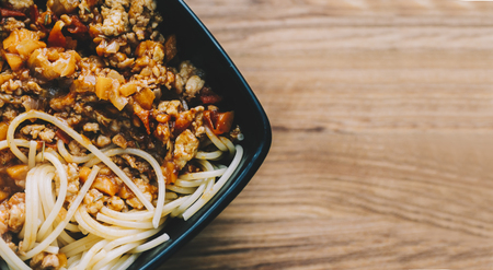Pasta with meat in plate on wooden tableの写真素材