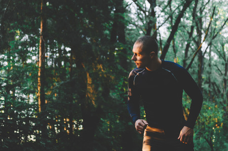 Young sportsmen running in city park in summer timeの写真素材