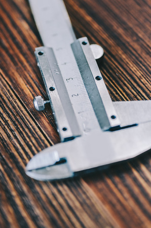 Caliper tool on wooden rustic tableの写真素材