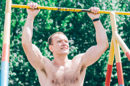40s man in city park fit on bars