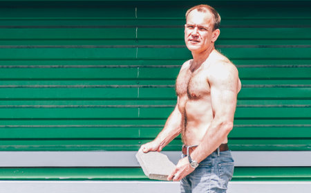 40s ma sitting on bench in hot summer dayの写真素材