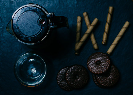 Teapot, cup and sweet cookies on black board