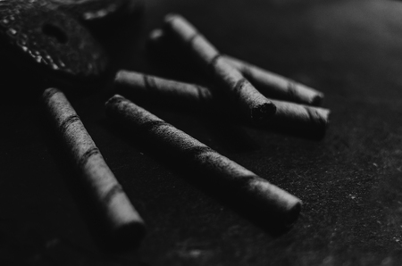 Black and white photo of the chocolate cookies and waffle tubes on the black boardの写真素材